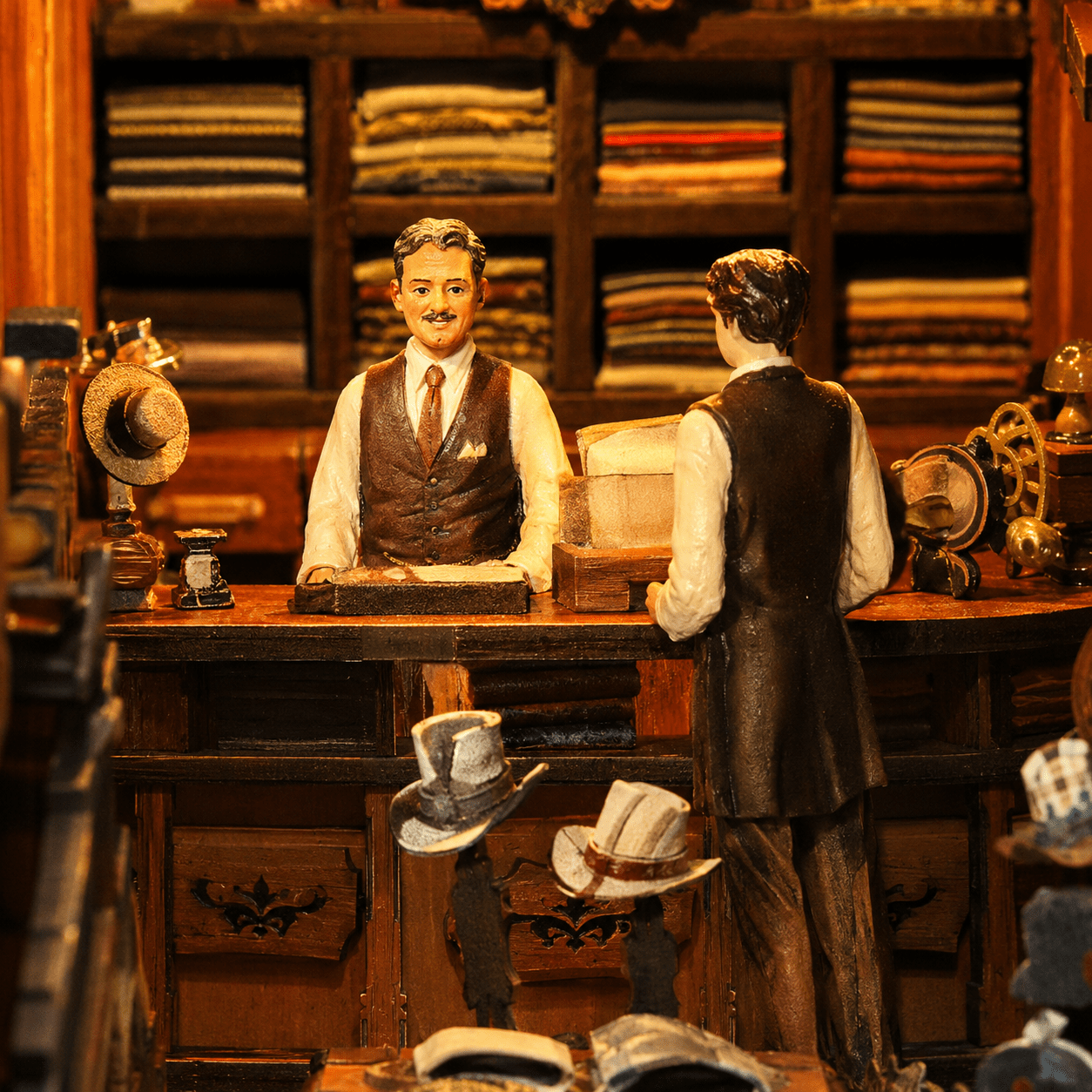 Royal Tailor Shop Book Nook Miniatur mit Schneiderfiguren, Arbeitstisch, Stoffdetails und historischem Ladenambiente