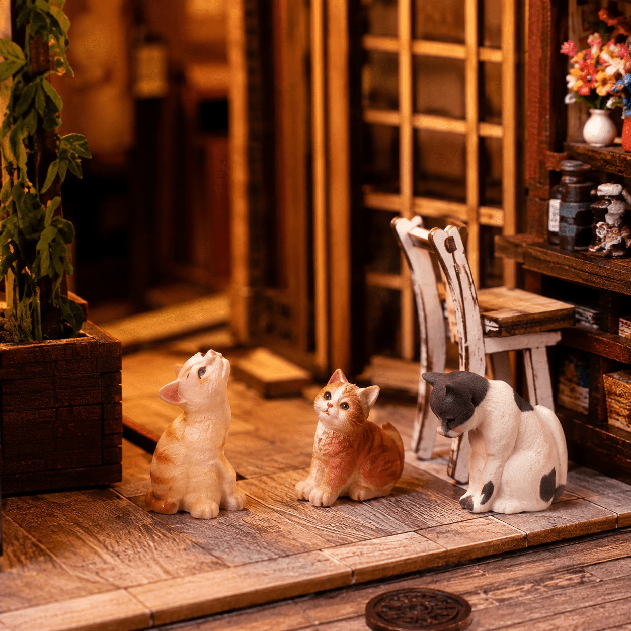 Japanese Cat Alley Book Nook Miniatur mit drei kleinen Katzenfiguren vor einem traditionellen japanischen Laden