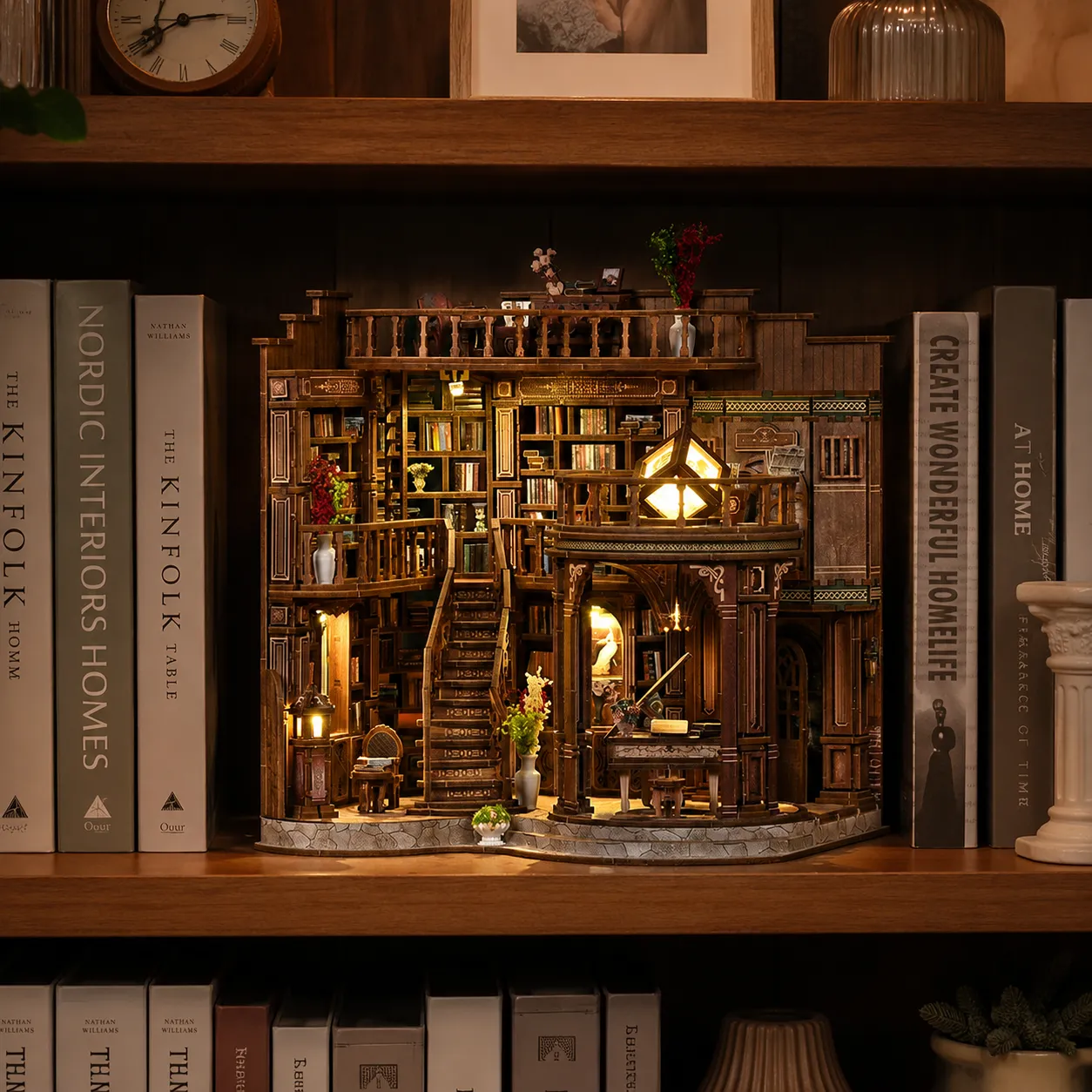 Beleuchtetes Miniaturhaus mit Bibliothek und Arbeitsbereich zwischen Büchern